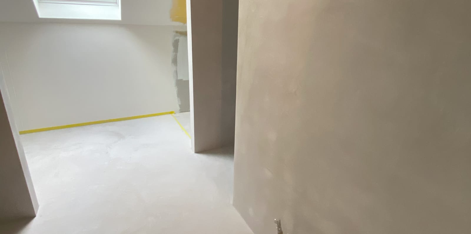 Microcement naadloos doorlopend over vloer en wand in een woning in Sint-Niklaas
