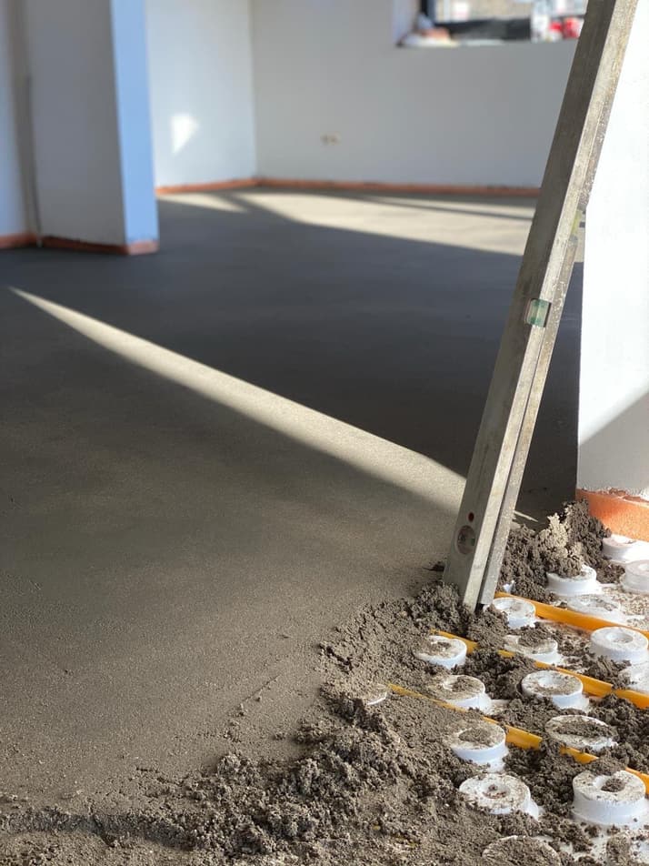 Chape gestort over vloerverwarmingsleidingen op noppenplaat