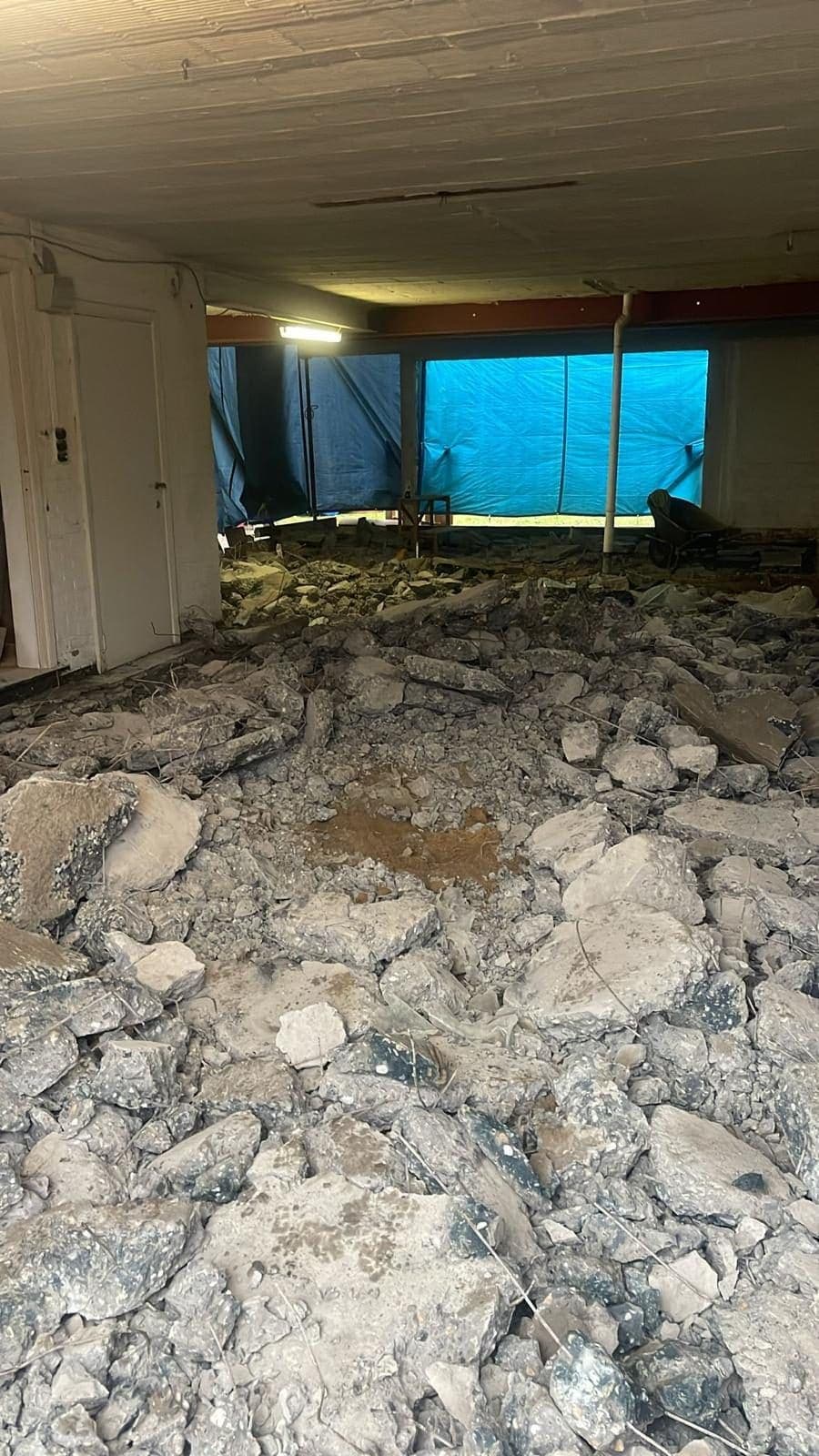 Afbraak van de bestaande vloer, puin op de grond